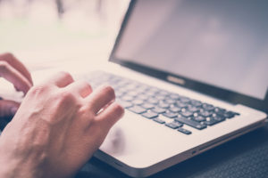 Registro de Marcas e Patentes - imagem de mão ao computador.